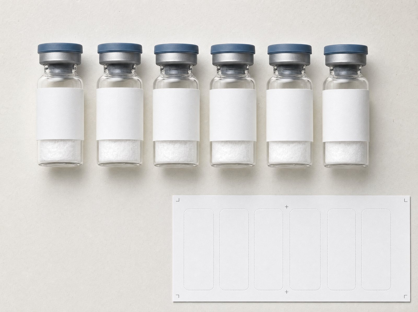 Unlabelled vials beside a label sheet